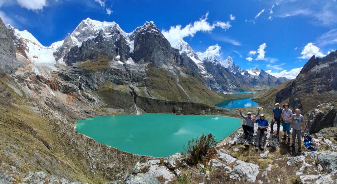 A small group of trekkers at a viewpoint above the turquoise lagoons.